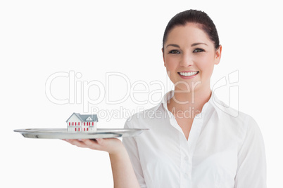 Waitress holding tray with miniature house