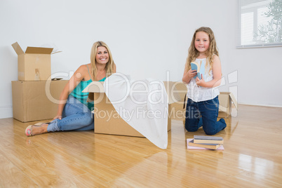 Smiling mother and daughter unpacking
