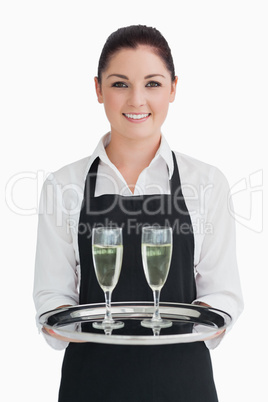 Smiling waitress holding tray with champagne
