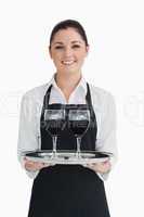 Cheerful waitress holding two glassed of wine