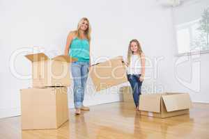 Mother and daughter carrying moving boxes