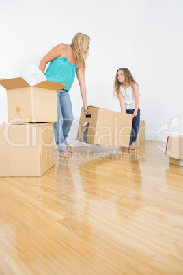 Mother and daughter lifting moving boxes
