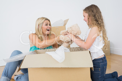 Mother and daughter unpacking teddy bear