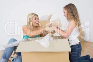 Mother and daughter unpacking teddy bear