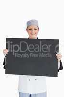 Smiling chef holding blackboard