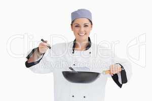 Happy cook cooking with wok and spoon