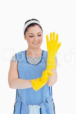Cleaner woman putting on yellow gloves