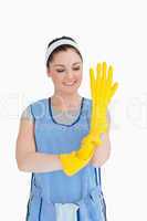 Cleaner woman putting on yellow gloves