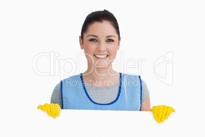 Smiling cleaning woman showing a white panel