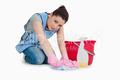 Exhausted cleaning woman wiping up the floor