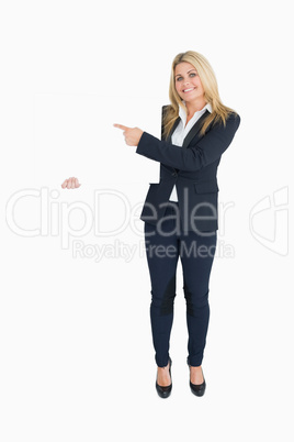 Smiling business woman showing a white panel