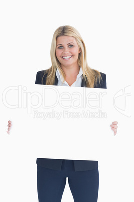 Happy business woman showing a white panel