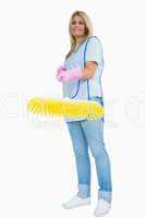 Smiling cleaner woman holding a yellow broom