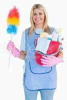 Cleaning woman holding feather duster with a bucket