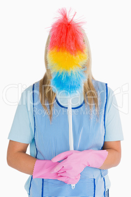 Cleaner holding a feather duster in front her face