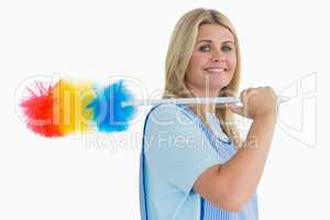 Smiling cleaning woman holding feather duster