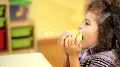 Children and healthy food, baby girl eating fruit at school