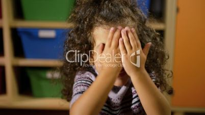 Happy little girl doing funny facial expressions at camera