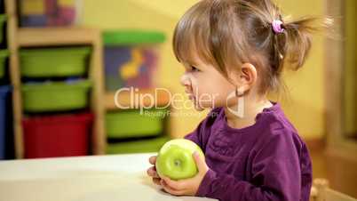 Baby and food, little girl eating green apple at school