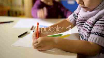 Children and fun, two happy preschoolers drawing in kindergarten