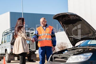 Woman shaking hands with mechanic car breakdown