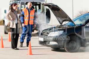 Woman with technician help smoking car engine
