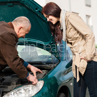 Man working on repairing a woman's car