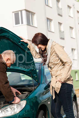 Man working on repairing a woman's car