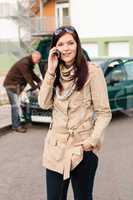 Woman on the phone repairman fixing car