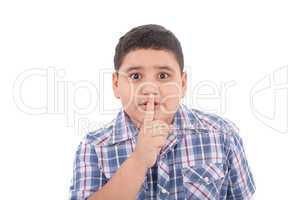 Portrait of beautiful little boy with silence gesture over white
