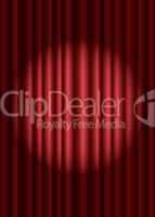 Closed red theater curtain with spotlight in the center
