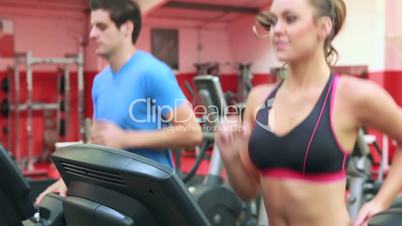 Woman and man running on a treadmill