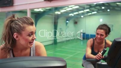 Women cycling on exercise bikes and chatting