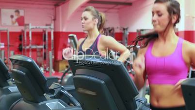 Two women running on treadmills