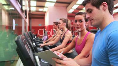 Trainer talking to woman on exercise bike