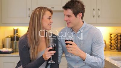Couple sitting in the kitchen drinking wine