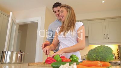 Couple cutting vegetables together