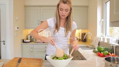 Woman mixing salad in the kitchen