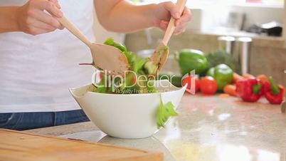 Woman is mixing salad