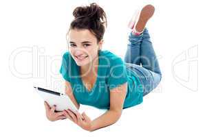 Causal teenager lying on floor holding new tablet pc