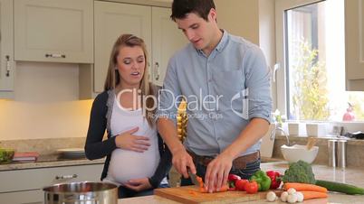 Man preparing vegetables for pregnant wife