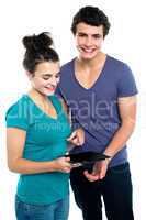 Gorgeous girl with her partner pointing at tablet pc