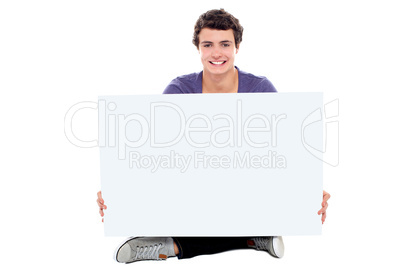 Teenager showing blank white billboard to camera