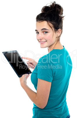 Trendy young casual girl operating tablet device