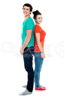 Adorable young couple posing back to back