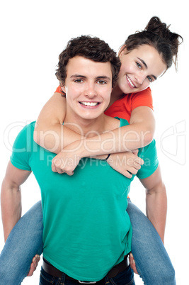 Casual shot of young guy giving piggy ride to his partner