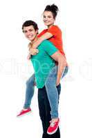 Handsome young man giving a piggyback ride to his girlfriend