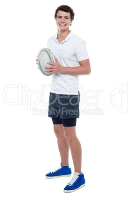 Full length portrait of a rugby player holding ball
