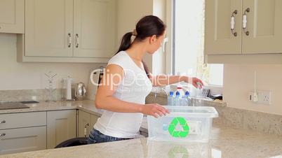 Woman putting bottles into recycling bin