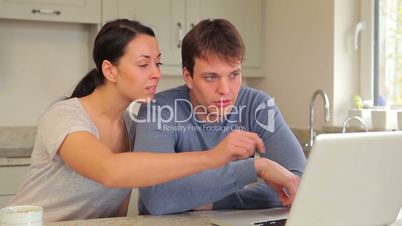 Couple looking at laptop and talking